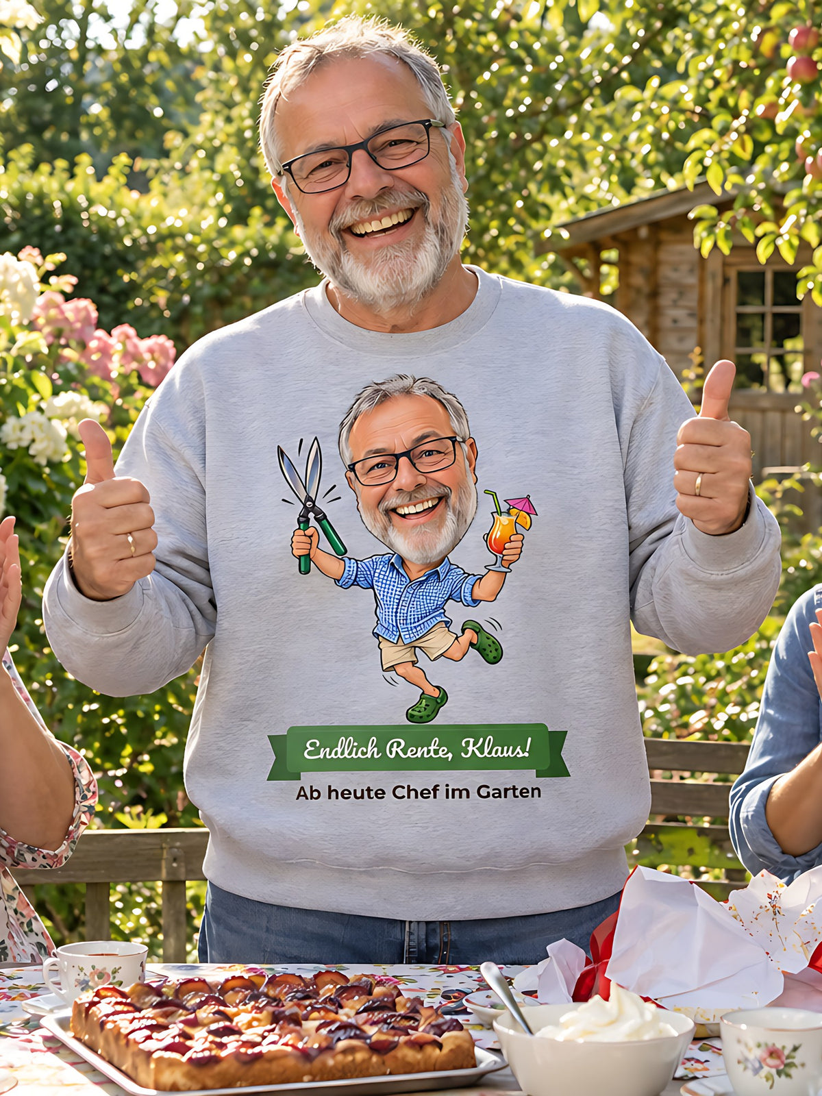 Beispielbild: hellgraues Sweatshirt mit lustiger Karikatur – Kaffee und Kuchen im Garten, Textband „Endlich Rente, Klaus!“